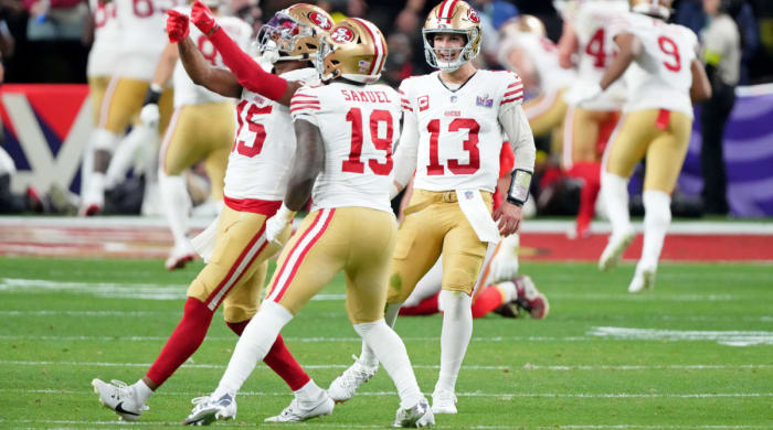 Brock Purdy smiles with Jauan Jennings and Deebo Samuel